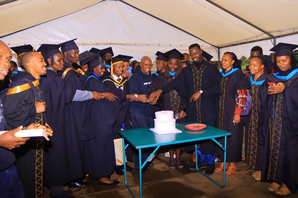 Graduants wit fr. Boniface during a cake cutting after graduands mass celebration.